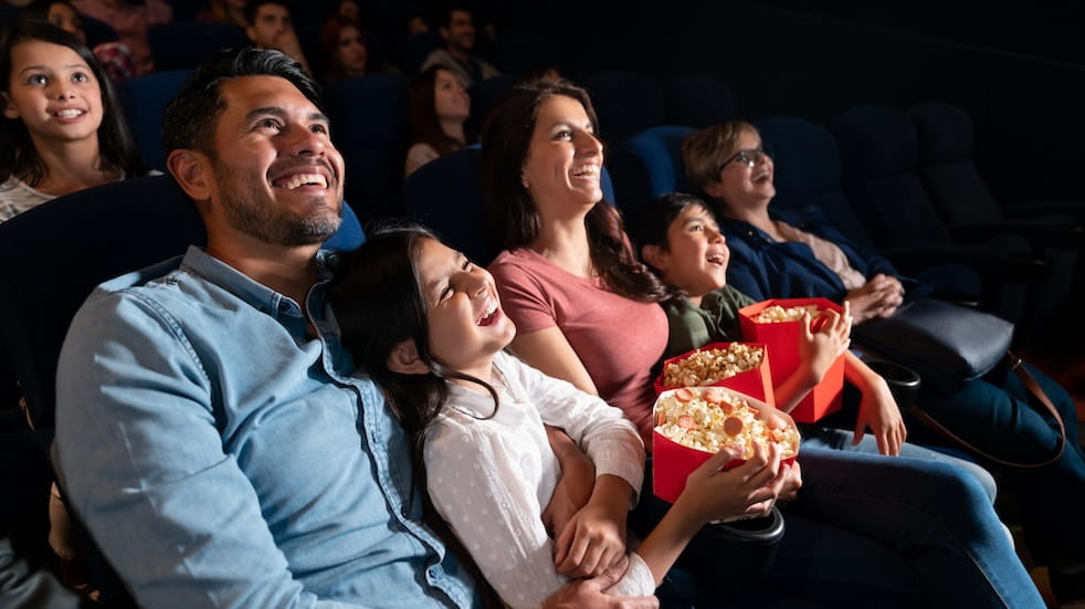 Happy family watching a comedy film at the cinema
